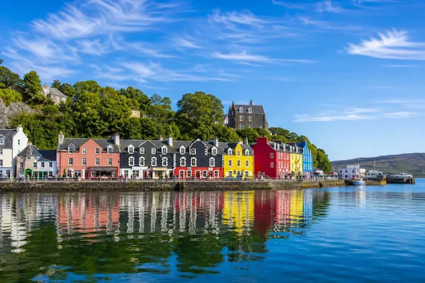 Cruisescapes direct cruise from Ireland showing colorful harbor buildings in Tobermory reflecting on calm blue waters.